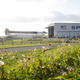 A photo of a SpaceX rocket laying on its side and rolling out of a hanger.